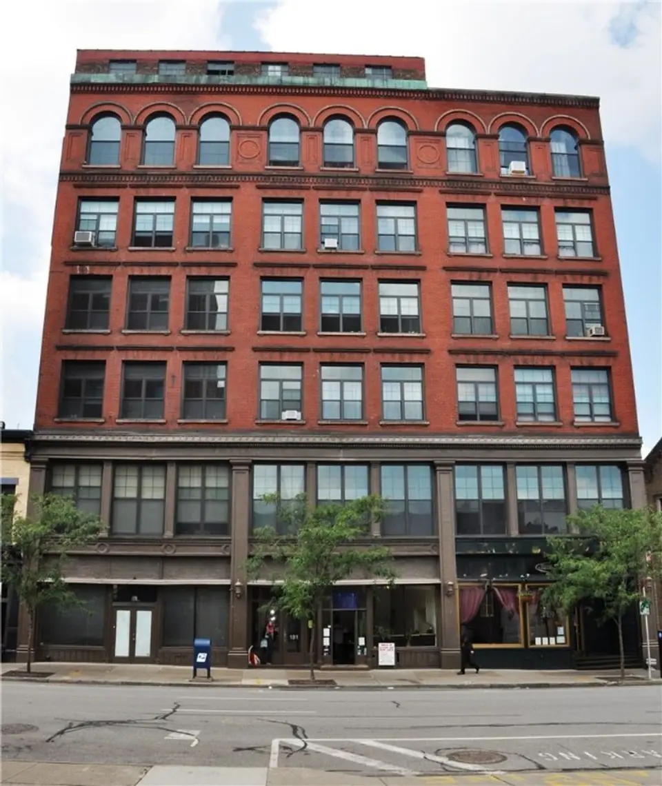 Seven-storey red-brick building with arched top-floor windows on St. Paul Street, downtown Rochester